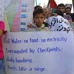 Yarmouk, agosto 2015, manifestazioni contro il perdurante assedio del campo profughi palestinese vicino a Damasco. 
